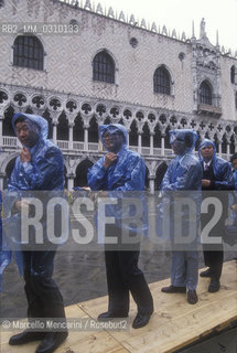 Venice, about 1990. Hig tide walkway in front of the Doges Palace / Venezia, 1990 circa. Passerelle per lacqua alta davanti a Palazzo Ducale - ©Marcello Mencarini/Rosebud2