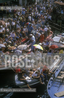 Venice, about 1990. People in boat attending  the historical regatta along the Grand Canal / Venezia, 1990 circa. Pubblico in barca che assiste alla regata storica sul Canal Grande - ©Marcello Mencarini/Rosebud2