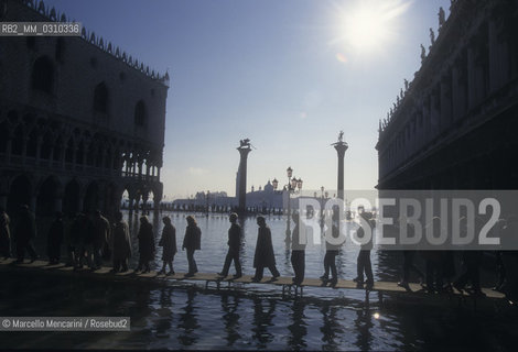 Venice, 1998. High Tide in St. Marks Square. Hig tide walkway in front of the St. Marks and St. Theodore Columns / Venezia, 1998. Acqua alta in Piazza San Marco. Passerelle davanti alle Colonne di San Marco e San Todaro - ©Marcello Mencarini/Rosebud2