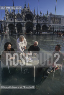 Venice, 1998. High Tide in St. Marks Square. People sitting at the Caffè Quadri outdoors tables / Venezia, 1998. Acqua alta in Piazza San Marco - ©Marcello Mencarini/Rosebud2
