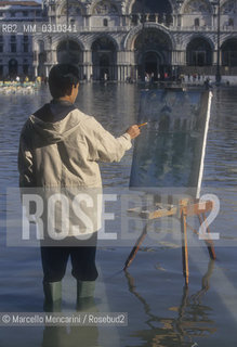 Venice, 1998. High Tide in St. Marks Square. Painter painting in the water / Venezia, 1998. Acqua alta in Piazza San Marco. Pittore che dipinge in mezzo allacqua - ©Marcello Mencarini/Rosebud2