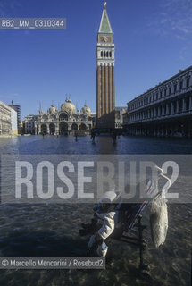 Venice, 1998. High Tide in St. Marks Square. Baby buggy in the water / Venezia, 1998. Acqua alta in piazza San Marco. Passeggino in mezzo allacqua - ©Marcello Mencarini/Rosebud2