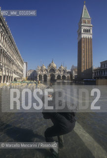 Venice, 1998. High Tide in St. Marks Square. A photograph in front of the St. Marks Basilica / Venezia, 1998. Acqua alta in Piazza San Marco. Fotografo di fronte alla basilica di San Marco - ©Marcello Mencarini/Rosebud2