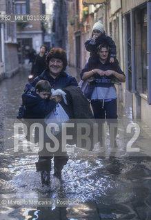 Venice, 1998. High Tide in St. Marks Square. Women with children on shoulders / Venezia, 1998. Acqua alta in Piazza San Marco. Donne con bambini sulle spalle - ©Marcello Mencarini/Rosebud2