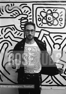 Italian journalist Roberto DAgostino wearing a Keith Haring t-shirt in front of a Keith Haring painting (about 1980) / Il giornalista Roberto DAgostino con una maglietta di Keith Harig davanti a un quadro di Keith Haring (1980 circa) - ©Marcello Mencarini/Rosebud2