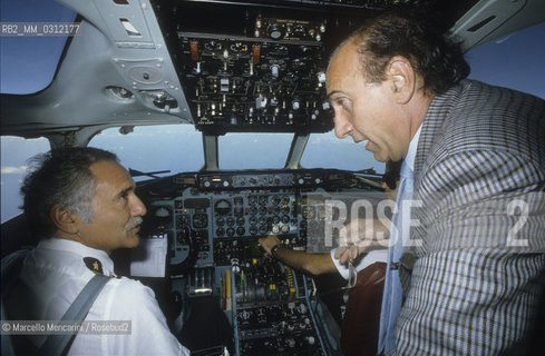 Italian TV presenter Pippo Baudo talking with the pilot on an airplane flying to his hometown Catania (1985) / Il presentatore TV Pippo Baudo in aereo verso la sua città natale Catania, mentre parla con il pilota (1985 circa) - ©Marcello Mencarini/Rosebud2