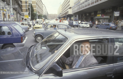 Italian TV presenter Pippo Baudo driving a car in his hometown, Catania (1985) / Il presentatore TV Pippo Baudo mentre guida a Catania, sua città natale (1985) - ©Marcello Mencarini/Rosebud2