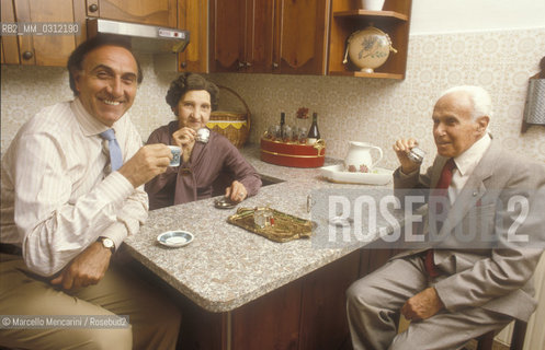 Catania, 1985. Italian TV presenter Pippo Baudo and his parents Giovanbattista Baudo and Innocenza Interlenghi drinking coffee in the kitchen their house / Catania, 1985. Il presentatore TV Pippo Baudo mentre beve un caffè con i suoi genitori, Giovanbattista Baudo e Innocenza Interlenghi, nella cucina della loro casa - ©Marcello Mencarini/Rosebud2
