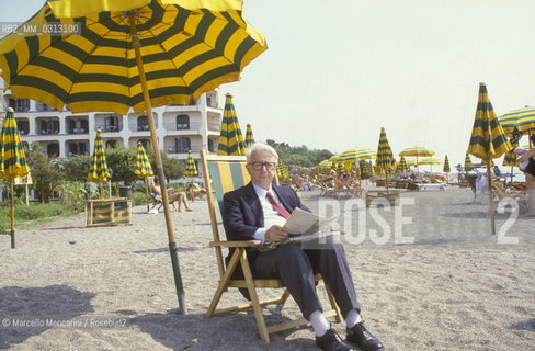 Giardini Naxos (Messina), 1986. Italian journalist Enzo Biagi -at Giardini Naxos to attend the National Award for Television Direction- on the beach of the Hilton Hotel / Giardini Naxos (Messina), 1986. Il giornalista Enzo Biagi -a Giardini Naxos per partecipare al Premio nazionale regia televisiva- sulla spiaggia dellHotel Hilton - ©Marcello Mencarini/Rosebud2