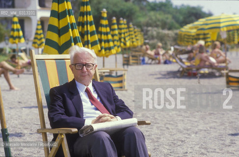 Giardini Naxos (Messina), 1986. Italian journalist Enzo Biagi -at Giardini Naxos to attend the National Award for Television Direction- on the beach of the Hilton Hotel / Giardini Naxos (Messina), 1986. Il giornalista Enzo Biagi -a Giardini Naxos per partecipare al Premio nazionale regia televisiva- sulla spiaggia dellHotel Hilton - ©Marcello Mencarini/Rosebud2