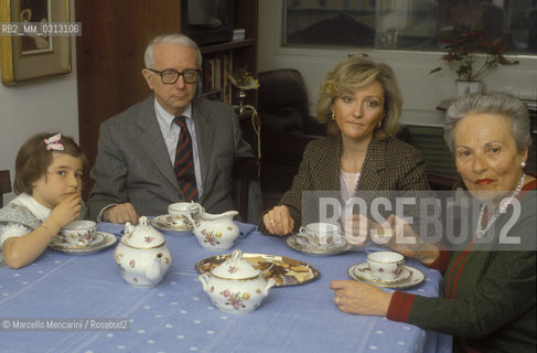 Milan, about 1988. Italian journalist Enzo Biagi takes tea in his living room with his daughter Bice Biagi, his wife Lucia Ghetti Biagi and his granddaughter Lucia Massarotti / Milano, 1988 circa. Il giornalista Enzo Biagi, prende il tè nel salotto di casa sua con la moglie Lucia Ghetti Biagi, la figlia Bice Biagi e la nipote Lucia Massarotti - ©Marcello Mencarini/Rosebud2