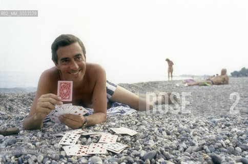 Magician Tony Binarelli with playing cards at the beach, 1986 / Il mago Tony Binarelli in spiaggia, 1986 - ©Marcello Mencarini/Rosebud2