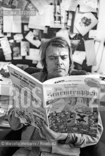 Bologna, 1981. Italian cartoonist Bonvi (Franco Bonvicini) in his studio holding an issue of his comic strip Sturmtruppern, 1981 / Il fumettista Bonvi (Franco Bonvicini) nel suo studio con un numero della sua striscia Sturmtruppen, 1981 - ©Marcello Mencarini/Rosebud2