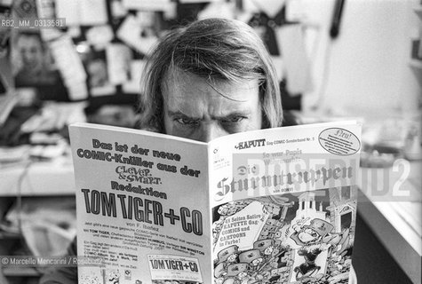 Bologna, 1981. Italian cartoonist Bonvi (Franco Bonvicini) in his studio holding an issue of his comic strip Sturmtruppern, 1981 / Il fumettista Bonvi (Franco Bonvicini) nel suo studio con un numero della sua striscia Sturmtruppen, 1981 - ©Marcello Mencarini/Rosebud2