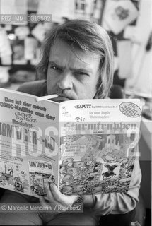 Bologna, 1981. Italian cartoonist Bonvi (Franco Bonvicini) in his studio holding an issue of his comic strip Sturmtruppern, 1981 / Il fumettista Bonvi (Franco Bonvicini) nel suo studio con un numero della sua striscia Sturmtruppen, 1981 - ©Marcello Mencarini/Rosebud2
