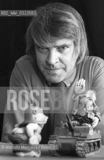 Bologna 1981. Italian cartoonist Bonvi (Franco Bonvicini) in his studio. Some little statues of his Sturmtruppen strip charachters are in the foreground / Bologna, 1981. Il fumettista Bonvi (Franco Bonvicini) nel suo studio con, in primo piano, alcune statuette di personaggi della sua striscia Sturmtruppen - ©Marcello Mencarini/Rosebud2