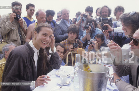 Cannes Film Festival, about 1985. French actress Carole Bouquet at table surrounded by the photographers / Festival del Cinema di cannes, 1985 circa. Lattrice Carole Bouquet a tavola circondata dai fotografi - ©Marcello Mencarini/Rosebud2