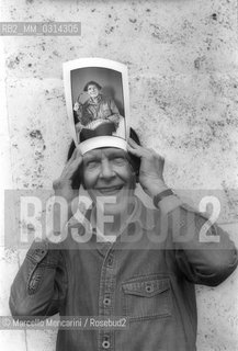 Roma, 1983. American composer John Cage holding a photo of him taken in the previous year in Venice by the same photographer / Roma, 1983. Il compositore John Cage tiene in mano una sua foto scattata lanno precedente a Venezia dallo stesso fotografo - ©Marcello Mencarini/Rosebud2
