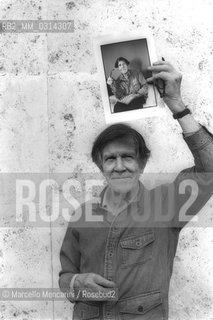 Roma, 1983. American composer John Cage holding a photo of him taken in the previous year in Venice by the same photographer / Roma, 1983. Il compositore John Cage tiene in mano una sua foto scattata lanno precedente a Venezia dallo stesso fotografo - ©Marcello Mencarini/Rosebud2