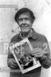 Roma, 1983. American composer John Cage holding a photo of him taken in the previous year in Venice by the same photographer / Roma, 1983. Il compositore John Cage tiene in mano una sua foto scattata lanno precedente a Venezia dallo stesso fotografo - ©Marcello Mencarini/Rosebud2