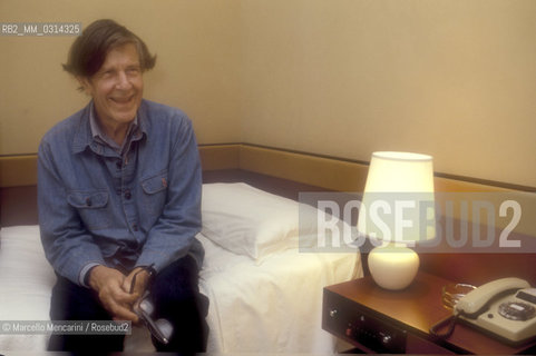 Venice, 1982. American composer John Cage sitting on the bed in his hotel room / Venezia, 1982. Il compositore John Cage seduto sul letto nella sua stanza dalbergo - ©Marcello Mencarini/Rosebud2