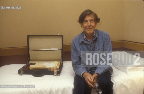 Venice, 1982. American composer John Cage sitting on the bed in his hotel room / Venezia, 1982. Il compositore John Cage seduto sul letto nella sua stanza dalbergo - ©Marcello Mencarini/Rosebud2