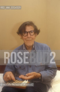 Venice, 1982. American composer John Cage sitting on the bed with a chessboard in his hotel room  / Venezia, 1982. Il compositore John Cage seduto sul letto con una scacchiera nella sua stanza dalbergo - ©Marcello Mencarini/Rosebud2