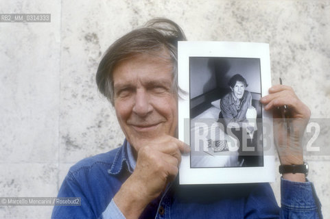 Roma, 1983. American composer John Cage holding a photo of him taken in the previous year in Venice by the same photographer / Roma, 1983. Il compositore John Cage tiene in mano una sua foto scattata lanno precedente a Venezia dallo stesso fotografo - ©Marcello Mencarini/Rosebud2