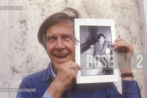 Roma, 1983. American composer John Cage holding a photo of him taken in the previous year in Venice by the same photographer / Roma, 1983. Il compositore John Cage tiene in mano una sua foto scattata lanno precedente a Venezia dallo stesso fotografo - ©Marcello Mencarini/Rosebud2