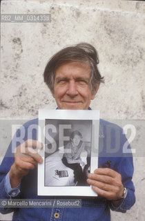 Roma, 1983. American composer John Cage holding a photo of him taken in the previous year in Venice by the same photographer / Roma, 1983. Il compositore John Cage tiene in mano una sua foto scattata lanno precedente a Venezia dallo stesso fotografo - ©Marcello Mencarini/Rosebud2