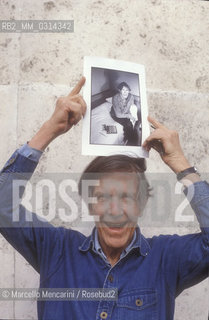 Roma, 1983. American composer John Cage holding a photo of him taken in the previous year in Venice by the same photographer / Roma, 1983. Il compositore John Cage tiene in mano una sua foto scattata lanno precedente a Venezia dallo stesso fotografo - ©Marcello Mencarini/Rosebud2