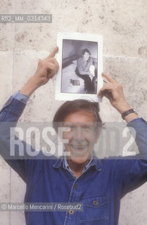 Roma, 1983. American composer John Cage holding a photo of him taken in the previous year in Venice by the same photographer / Roma, 1983. Il compositore John Cage tiene in mano una sua foto scattata lanno precedente a Venezia dallo stesso fotografo - ©Marcello Mencarini/Rosebud2