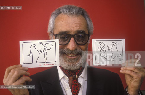 Lucca, 1990. Italian cartoonist Osvaldo Cavandoli holding two drawing of his character La Linea (The Line) / Lucca, 1990. Il disegnatore di fumetti Osvaldo Cavandoli posa tenendo in mano due disegni del suo personaggio La Linea - ©Marcello Mencarini/Rosebud2