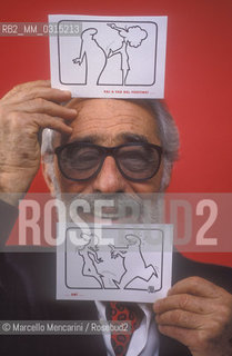 Lucca, 1990. Italian cartoonist Osvaldo Cavandoli holding two drawing of his character La Linea (The Line) / Lucca, 1990. Il disegnatore di fumetti Osvaldo Cavandoli posa tenendo in mano due disegni del suo personaggio La Linea - ©Marcello Mencarini/Rosebud2