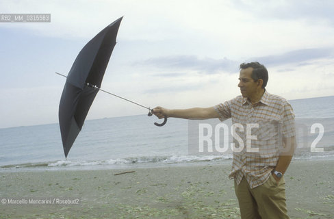 Venice, 1982. Italian composer Aldo Clementi holding an umbrella on the Lido seashore/ Venezia, 1982. Il compositore Aldo Clementi sulla spiaggia del Lido con un ombrello - ©Marcello Mencarini/Rosebud2