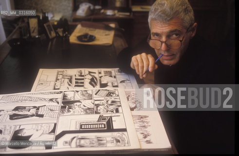 Milan, 1993. Italian cartoonist Guido Crepax sitting at his studio drawing table with pictures of his character Valentina / Milano, 1993. Il fumettista Guido Crepax nel suo studio mentre disegna tavole del suo personaggio Valentina - ©Marcello Mencarini/Rosebud2