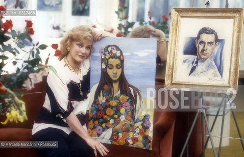Rome, 1986. American actress Linda Christian showing the portraits of her daughter Romina and of her husband Tyrone Power painting by herself / Roma, 1986. Lattrice  Linda Christian con i ritratti della figlia Romina Power e del marito Tyrone Power dipinti da lei - ©Marcello Mencarini/Rosebud2