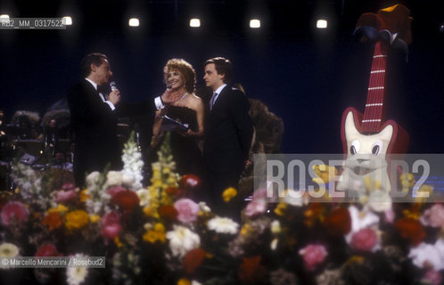 Sanremo Music Festival, 1990. Italian pop singer Gianluca Guidi (last from the left) -at the Festival with the song Secondo te, that will finish third in the New Proposals Category- with his father Johnny Dorelli and Gabrierlla Carlucci, Festival TV presenters / Festival doi Sanremo 1990. Gianluca Guidi (ultimo da sinistra) -al Festival con la canzone Secondo te, che si classificherà terza nella categoria Nuove proposte- con suo padre Johnny Dorelli e Gabriella Carlucci, presentatori del Festival - ©Marcello Mencarini/Rosebud2