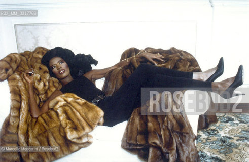 Rome, 1986. Fashion model and pop singer Grace Jones poses lying on a sofa with some Fendi furs / Roma, 1986. La modella e cantante Grace Jones posa distesa su un divano con alcune pellicce Fendi - ©Marcello Mencarini/Rosebud2