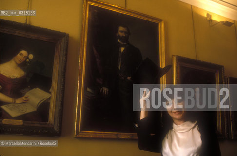 Milan, 1990. Italian soprano Tiziana Fabbricini in La Scala Theater Museum in front of a portrait of composer Giuseppe Verdi / Milano, 1990. Il soprano Tiziana Fabbricini nel Museo del Teatro alla Scala davanti a un ritratto di Giuseppe Verdi - ©Marcello Mencarini/Rosebud2