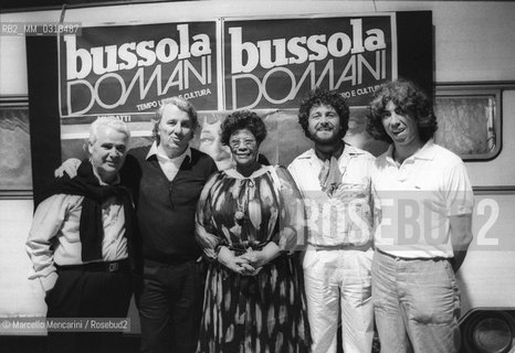 Le Focette (Tuscany), August 1980. Jazz singer Ella Fitzgerald at Bussoladomani before performing in a concert with guitarist Joe Pass. Next to her, owner of Bussoladomani Sergio Bernardini (third from left), comedian Beppe Grillo presenter of the show (fourth from left), and music manager Francesco Sanavio (fifth from left)  / Le Focette, località di Marina di Pietrasanta (Lucca), agosto 1980. La cantante Ella Fitzgerald a Bussoladomani prima di esibirsi in un concerto con il chitarrista Joe Pass. Accanto a lei, Sergio Bernardini proprietario di Bussoladomani (terzo da sinistra), il comico Beppe Grillo presentatore della serata (quarto da sinistra) e lorganizzatore musicale Francesco Sanavio - ©Marcello Mencarini/Rosebud2