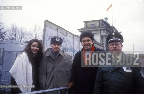 Berin, 1990. Fabrizio Frizzi and Elisabetta Gardini, hosts of the Italian TV program Europa Europa, with two soldiers in front of the Berlin Wall / Berlino, 1990. Fabrizio Frizzi ed Elisabetta Gardini, presentatori del programma televisivo Europa Europa, con due soldati davanti al Muro di Berlino - ©Marcello Mencarini/Rosebud2