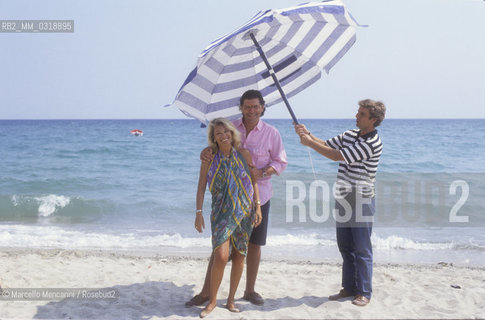 Sicily, 1991. Italian TV presenters Fabrizio Frizzi and Rita dalla Chiesa with TV writer Marco Luci / Sicilia, 1991. I presentatori Fabrizio Frizzi e Rita dalla Chiesa con lautore televisivo Marco Luci- ©Marcello Mencarini/Rosebud2