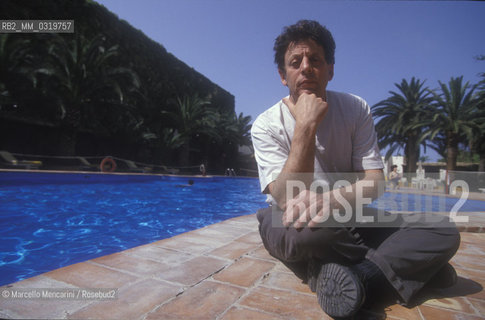 Gibellina (Trapani) 1994. Composer Philip Glass on the edge of the swimming pool of his hotel in the days of the rehearsals before the premiere of his opera for ensemble and film La Belle et la Bête / Gibellina (Trapani) 1994. Il compositore Philip Glass sul bordo della piscina del suo albergo nei giorni delle prove per la prima della sua opera La belle et la bête - ©Marcello Mencarini/Rosebud2