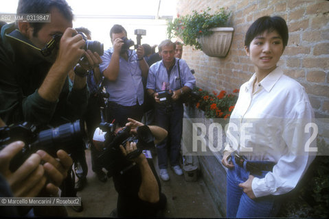Venice Lido, Venice Film Festival 1992. Chinese actress Gong Li -winner of the Coppa Volpi Award for best actress for her role in the movie  The story of Qiu Ju (Qiu Ju da guansi) by  Zhang Yimou, winner of Golden Lion Award for Best Film- shot by photographers / Lido di Venezia, Mostra del Cinema di Venezia 1992. Lattrice cinese Gong Li -vincitrice della Coppa Volpi per la migliore attrice per il suo ruolo nel film  La storia di Qiu Ju (Qui Ju da guansi) di  Zhang Yimou, vincitore del Leone doro per il miglior film- ripresa dai fotografi - ©Marcello Mencarini/Rosebud2