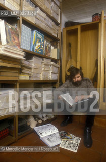 Bologna, 1985. Italian singer-songwriter Francesco Guccini in his house at via Paolo Fabbri 43, shows his comic book collection / Bologna, 1985 circa. Il cantautore Francesco Guccini nella sua casa di via Paolo Fabbri 43 mostra la sua collezione di fumetti - ©Marcello Mencarini/Rosebud2