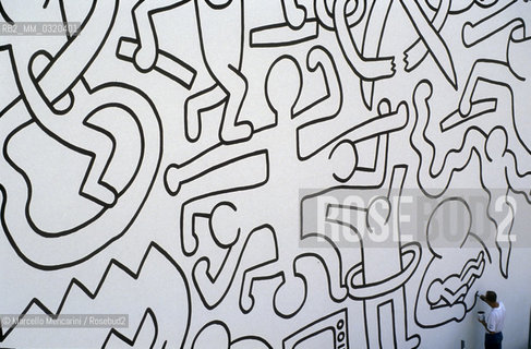 Artist Keith Haring working at the mural Tuttomondo on the rear wall of the Church of SantAntonio in Pisa, 1989 / Lartista Keith Haring mentre lavora al murale Tuttomondo sul muro posteriore della chiesa di SantAntonio abate a Pisa, 1989 - ©Marcello Mencarini/Rosebud2