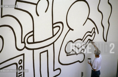 Artist Keith Haring working at the mural Tuttomondo on the rear wall of the Church of SantAntonio in Pisa, 1989 / Lartista Keith Haring mentre lavora al murale Tuttomondo sul muro posteriore della chiesa di SantAntonio abate a Pisa, 1989 - ©Marcello Mencarini/Rosebud2