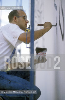 Artist Keith Haring working at the mural Tuttomondo on the rear wall of the Church of SantAntonio in Pisa, 1989 / Lartista Keith Haring mentre lavora al murale Tuttomondo sul muro posteriore della chiesa di SantAntonio abate a Pisa, 1989 - ©Marcello Mencarini/Rosebud2