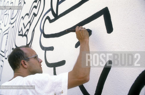 Artist Keith Haring working at the mural Tuttomondo on the rear wall of the Church of SantAntonio in Pisa, 1989 / Lartista Keith Haring mentre lavora al murale Tuttomondo sul muro posteriore della chiesa di SantAntonio abate a Pisa, 1989 - ©Marcello Mencarini/Rosebud2